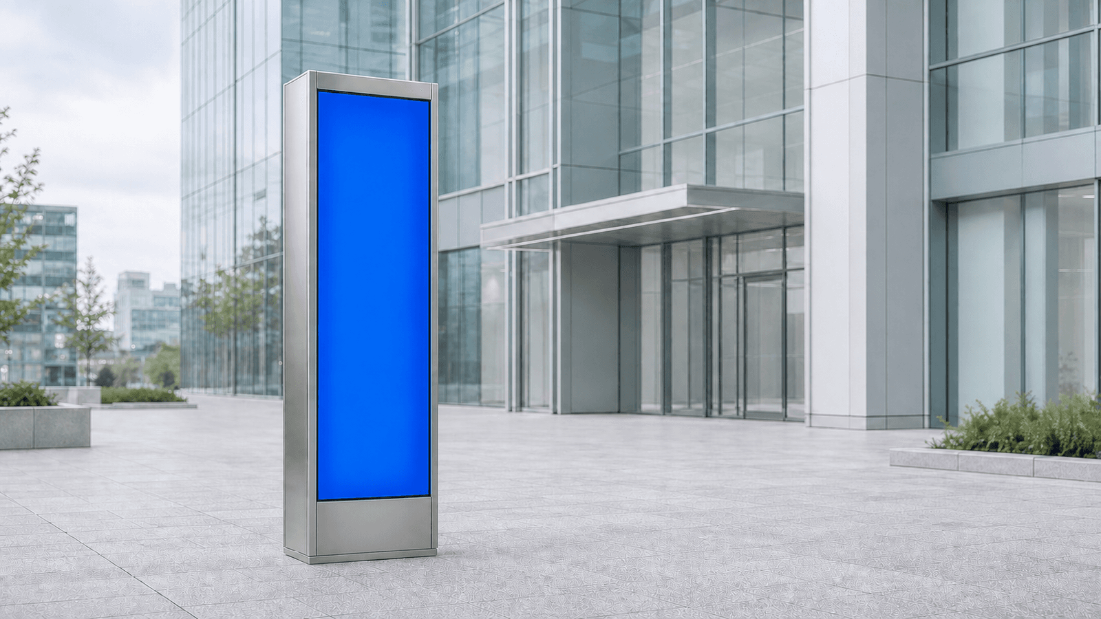 A daylight view of a modern glass office tower plaza with a single illuminated cobalt wayfinding pillar in the foreground