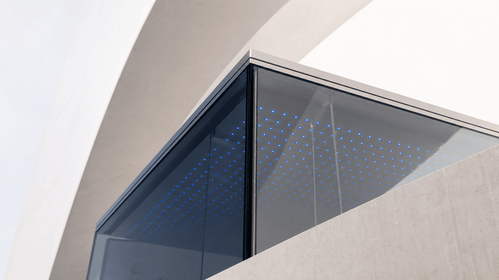 A sharp architectural glass corner reflecting a grid of small cobalt-blue light points